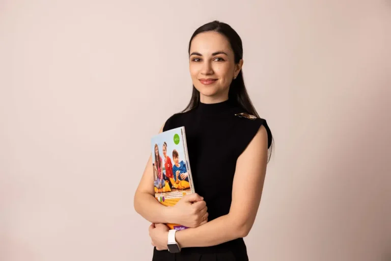 Profesoară GermanABC ține în mână manualul Schritte Neo A1 în timpul unei lecții de germană